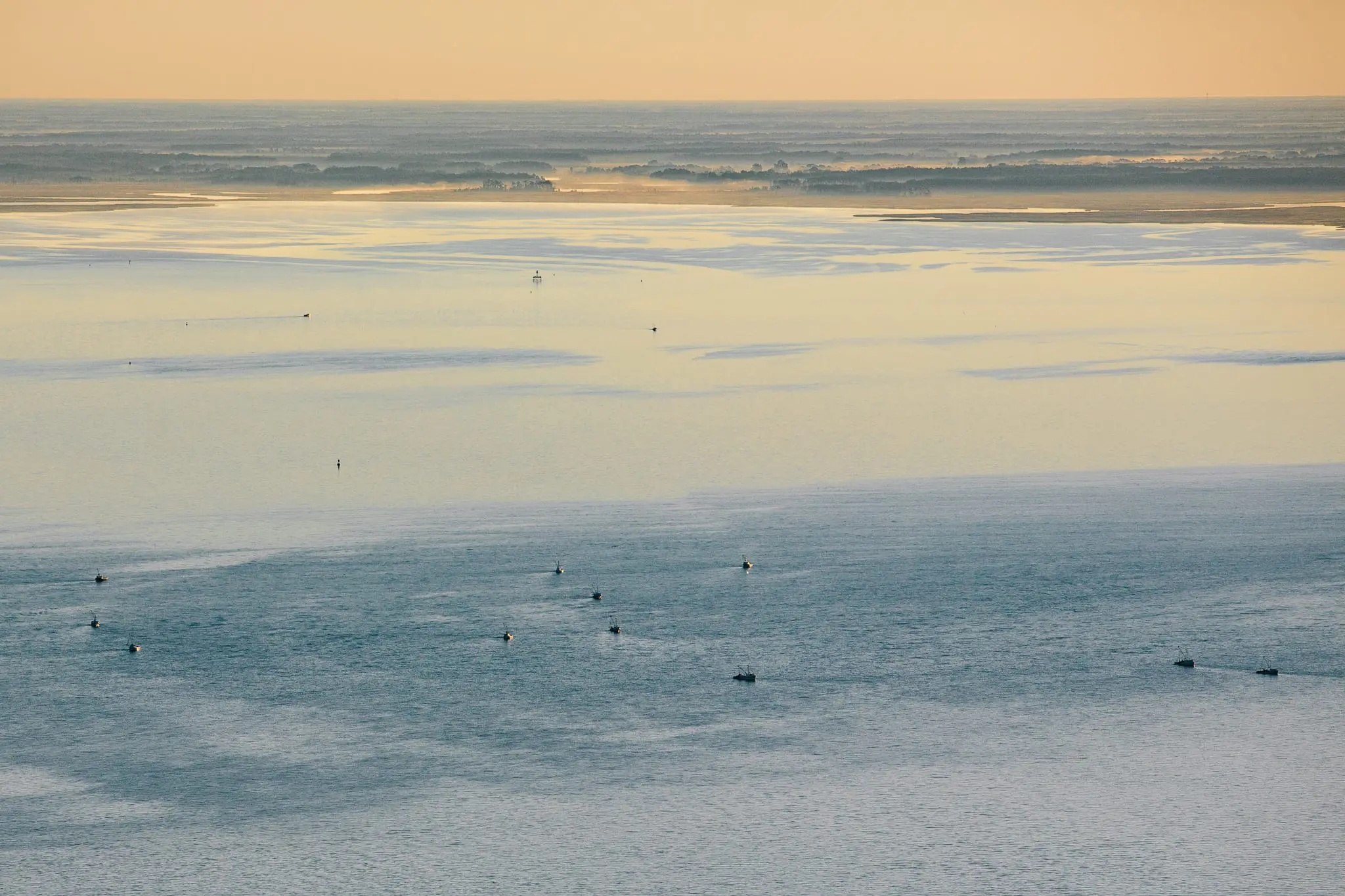 Crab boats at sunrise head out into the bay.