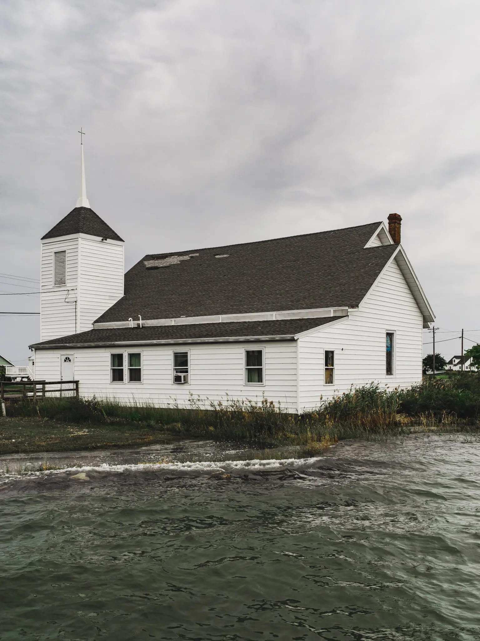 A church on Hoopers Island with waves lapping against it.