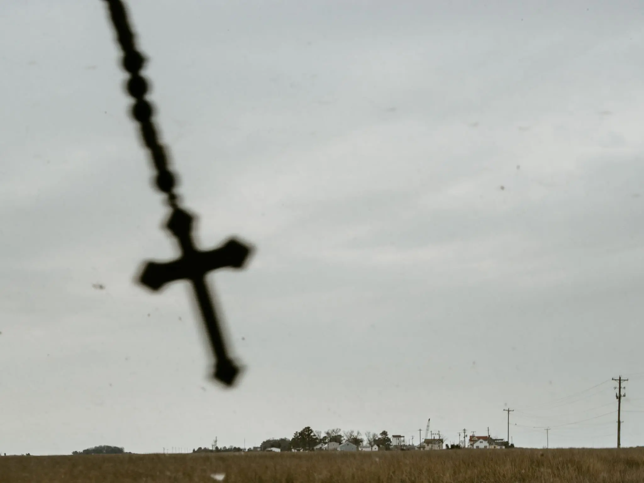 A cross swings in the windshield of a car on Smith Island.